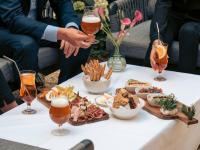 a group of people sitting around a table with food and drinks at Hôtel Alfred Sommier in Paris