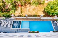 a blue swimming pool with white chairs and a picture at Alexis Hotel in Chania Town