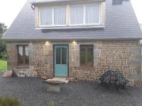 a brick house with a blue door and a window at La Bannerie in Mesnil-Clinchamps