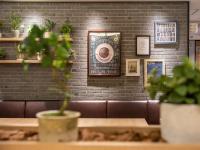 a brick wall with pictures and a potted plant at Super Hotel Tottori Ekimae in Tottori