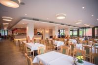 Un comedor con mesas y sillas blancas. en Lobogo Resort, en Vlăhiţa