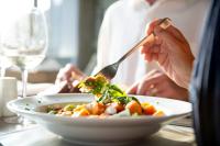 a person eating a plate of food on a table at Simola Hotel, Country Club & Spa in Knysna