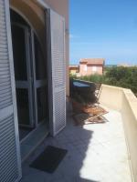 a balcony with a door and a chair on a patio at residence Mare Turchinu in Monticello