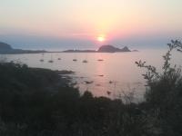 a group of boats in the water at sunset at residence Mare Turchinu in Monticello