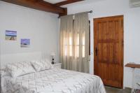 a bedroom with a bed and a wooden door at Hostal El Espinel in Zahara de los Atunes