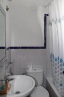 a white bathroom with a toilet and a sink at Hostal El Espinel in Zahara de los Atunes