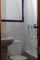 a bathroom with a toilet and a sink and a shower curtain at Hostal El Espinel in Zahara de los Atunes
