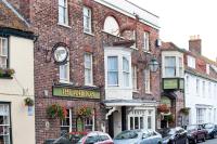 Un edificio con un reloj en el costado. en Antelope by Greene King Inns, en Poole