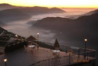 a balcony with tables and chairs and a view of the mountains at Star Villa in Ren&#39;ai