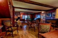 a dining room with chairs and tables and a stone wall at Auberge Handfield et Spa in Saint-Marc-sur-Richelieu