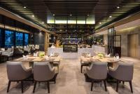 a restaurant with wooden tables and chairs and a bar at Wyndham Grand Maoming in Maoming