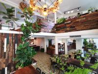 a room with tables and potted plants in a restaurant at 6號花園別墅酒店 Shenzhen No'6 Garden Villa --French Window with garden view,Close to Sea World &Shekou Ferry Port &K11 Ecoast &Subway Nearby ,Offer Western food and coffee &English speaking with tour services in Shenzhen