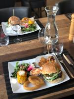 dos platos de comida en una mesa con copas de vino en Hôtel Génépi, en Beuil