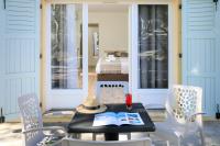 a table with a hat and a book on a porch at Joseph Charles in LʼÎle-Rousse