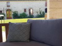 a pillow sitting on a couch in front of a house at Les Hauts De Chalonne in Le Gond-Pontouvre