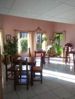 a dining room with a table and chairs and windows at Hosteria Andina in Esquel
