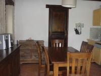 a kitchen with a wooden table and wooden chairs at Le Mas De La Chérine in Quinson