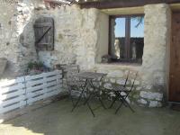 a table and chairs in front of a stone building at Le Mas De La Chérine in Quinson