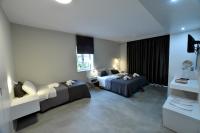 A bed or beds in a room at Olive Press Hotel & Apartments