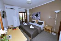 A bed or beds in a room at Olive Press Hotel & Apartments