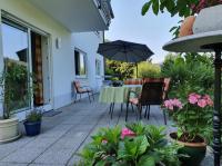 a patio with a table and chairs and an umbrella at Urlaubs(t)raum in Heiligkreuzsteinach