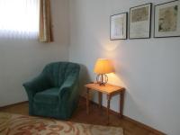 a green chair sitting next to a table with a lamp at Fritz&#39;es Goldener Stern in Schauenburg