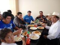 een groep mensen die rond een tafel pizza eten bij Gran Hotel Virrey in San Ramón