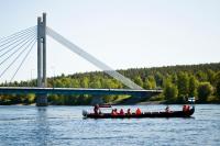 a group of people on a boat in the water near a bridge at Original Sokos Hotel Vaakuna Rovaniemi in Rovaniemi