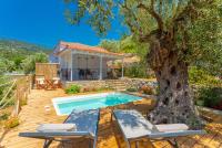 a house with a swimming pool and a tree at Neptune in Alonnisos