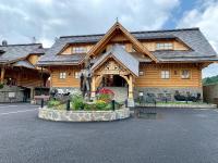 a log cabin with a statue in front of it at Zbojnicky penzion in Oravska Jasenica