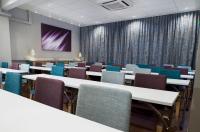 a conference room with tables and chairs and a screen at Original Sokos Hotel Vaakuna Rovaniemi in Rovaniemi