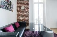 a living room with a black couch and a brick wall at Gorgeous Paris Eiffel Tower in Paris