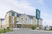 Un gran edificio con un cartel delante. en Quality Inn &amp; Suites Thompson, en Thompson