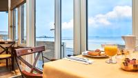 a table with a plate of food and a glass of orange juice at Hôtel Le Beaufort in Saint Malo