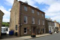 an old brick building on the corner of a street at Kings Arms Hotel in Melrose