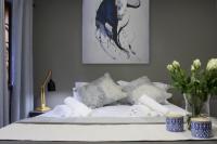 a bed with white sheets and pillows and a vase of flowers at 31 at Murray in Pretoria