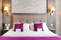 a bedroom with a large bed with purple and white pillows at Best Western Hotel Saint Claude in Péronne