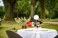 Hôtel Restaurant Gastronomique La Huchette في ماكون: طاولة بيضاء عليها كؤوس نبيذ وصبار