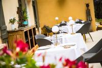 Hôtel Restaurant Gastronomique La Huchette في ماكون: صف من الطاولات مع مفارش الطاولات البيضاء