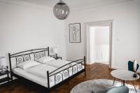 Schlafzimmer mit einem schwarzen und weißen Bett und einem Tisch in der Unterkunft Das Gästehaus in Sankt Veit am Vogau