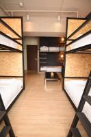 a room with three bunk beds and a table at NK Hostel in Taipei