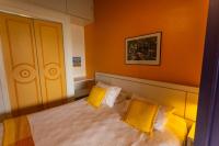 a bedroom with a bed with two yellow pillows at Pousada DiMari in Boicucanga