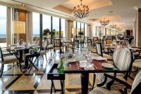 a restaurant with tables and chairs and a chandelier at Grande Real Villa Itália Hotel & Spa in Cascais