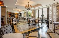 a dining room with tables and chairs and windows at Grande Real Villa Itália Hotel & Spa in Cascais