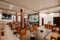 un ristorante con tavoli e sedie e un grande schermo di Lake Hills Hotel a Ha Long