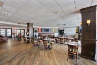 a dining room with tables and chairs and a screen at Chateau Roberval in Roberval