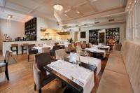 a restaurant with tables and chairs and a bar at Artis Boutique Hotel in Szombathely