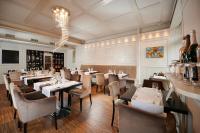 a restaurant with tables and chairs and a chandelier at Artis Boutique Hotel in Szombathely