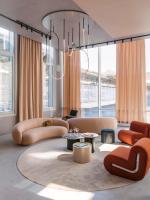 ein Wohnzimmer mit Sofas, Tischen und Fenstern in der Unterkunft OKKO Hotels Paris Gare de l'Est in Paris