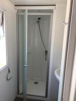 a shower with a glass door in a bathroom at Camping le Rhône in Tournon-sur-Rhône
